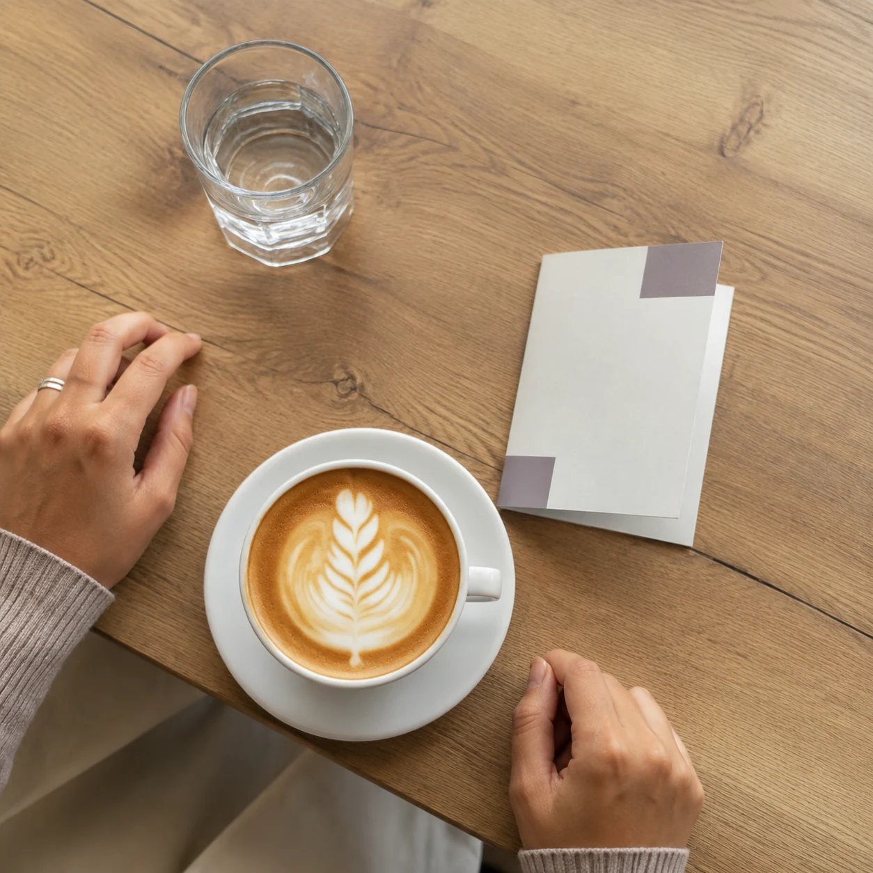 Coffee and a simple invitation card on a cafe table